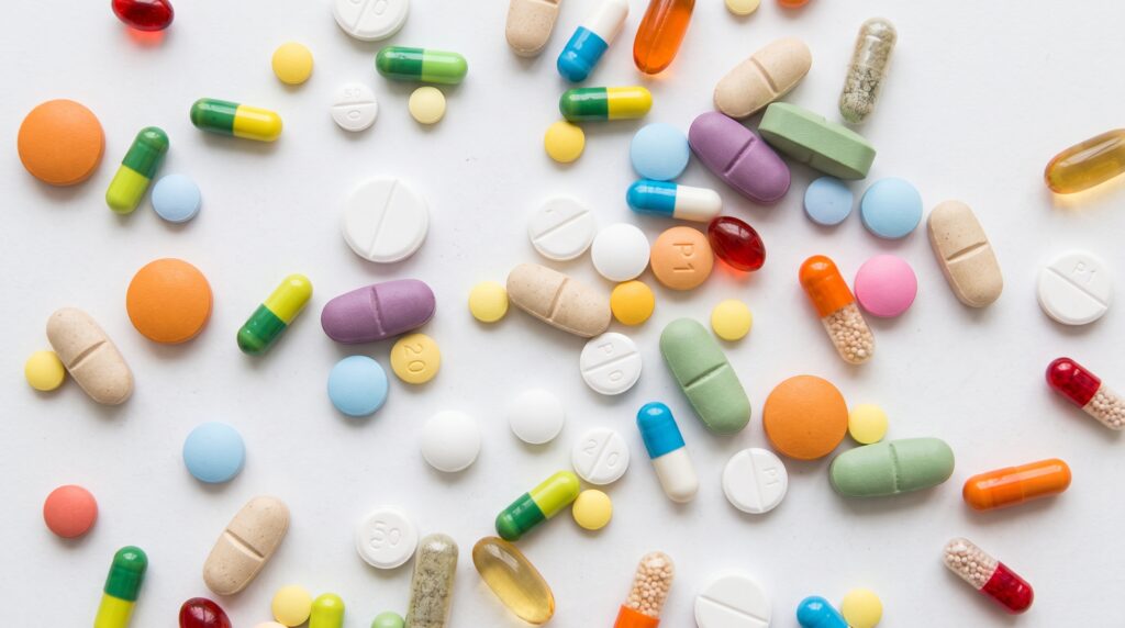 Pastillas y cápsulas de colores que representan medicamentos que pueden resecar los ojos